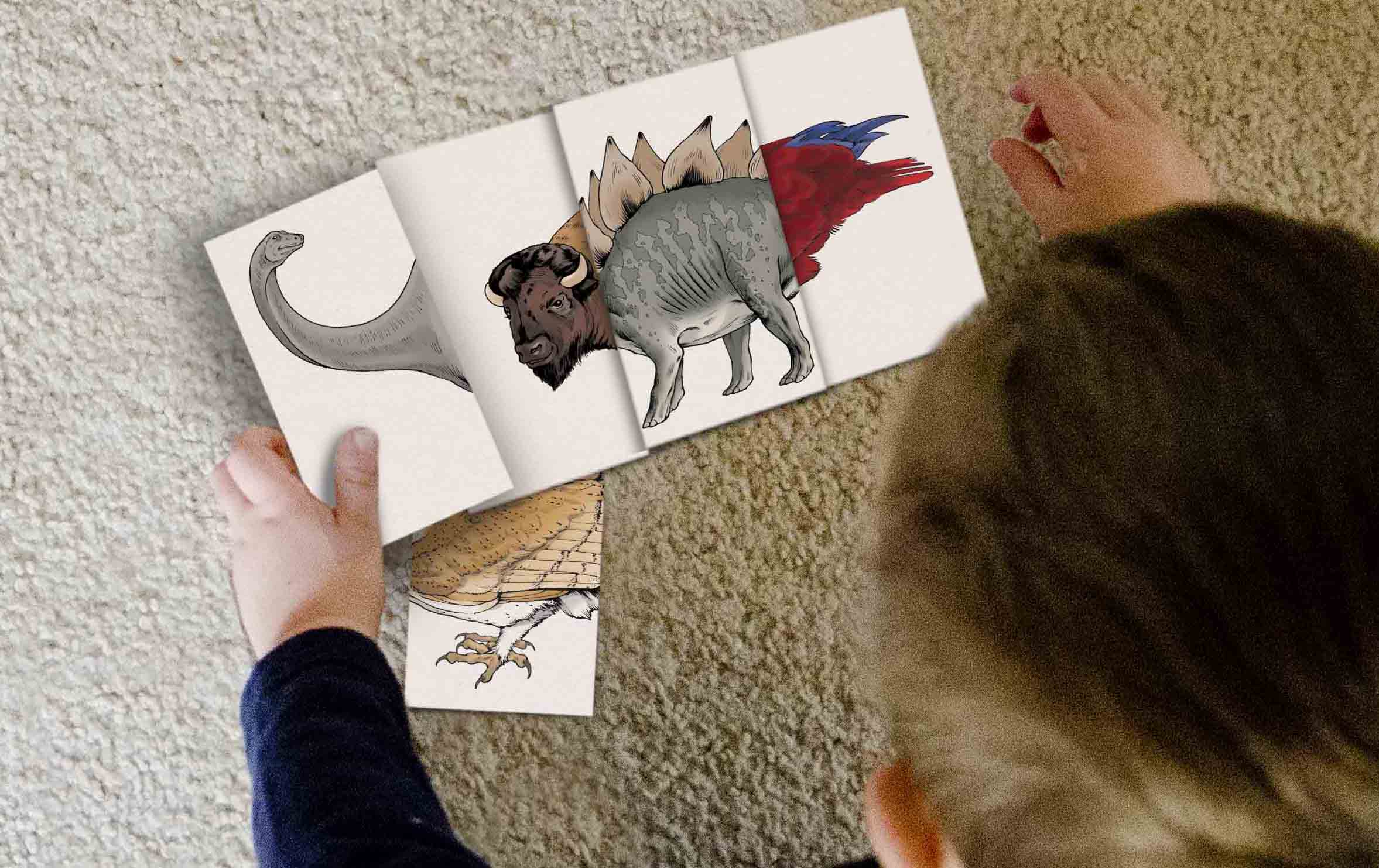 An photo mockup of a child playing with cards taken from above. The child's blond head blocks most of the right side of the image. They are playing on a light beige carpet. Three illustrated animal cards are lined up together so that they form a creature with the head of a buffalo, the body of a stegosaurus, and the tail of a parrot. At an angle and partially underneath those cards is a card with the body of an owl. In the child's hand is a card with the head of a brachiosaurus. The child is either about to place the card over the buffalo's head, or is removing it to show the bison's head.